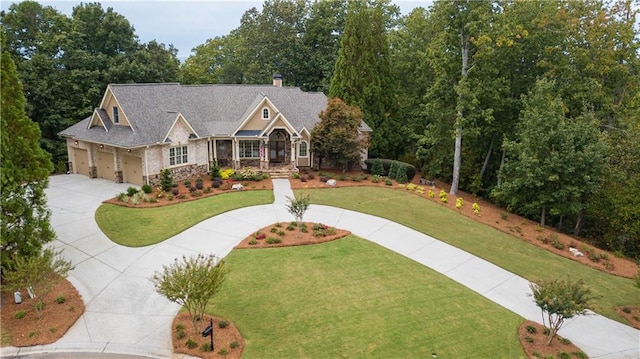 craftsman inspired home with a garage and a front lawn