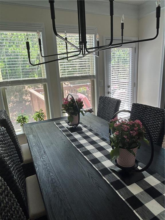 dining space featuring a wealth of natural light and an inviting chandelier