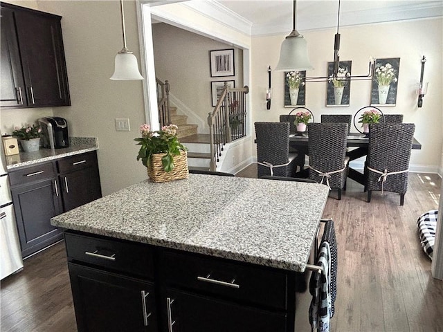 kitchen featuring crown molding, dark hardwood / wood-style floors, a center island, and hanging light fixtures