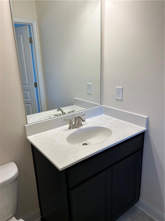 bathroom featuring vanity, tile patterned floors, and toilet