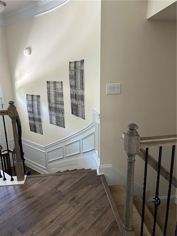 stairs featuring hardwood / wood-style flooring and ornamental molding