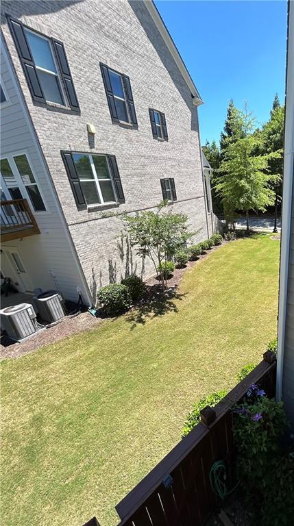 view of side of property featuring cooling unit and a yard