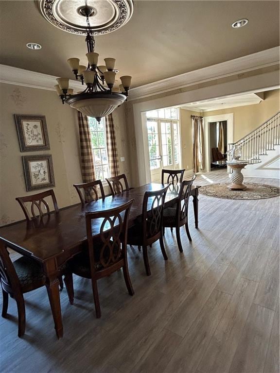 dining room with a chandelier, ornamental molding, and wood-type flooring