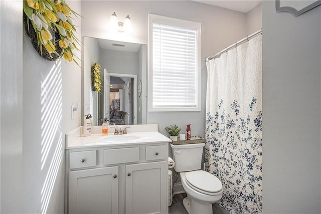 bathroom with vanity, curtained shower, and toilet