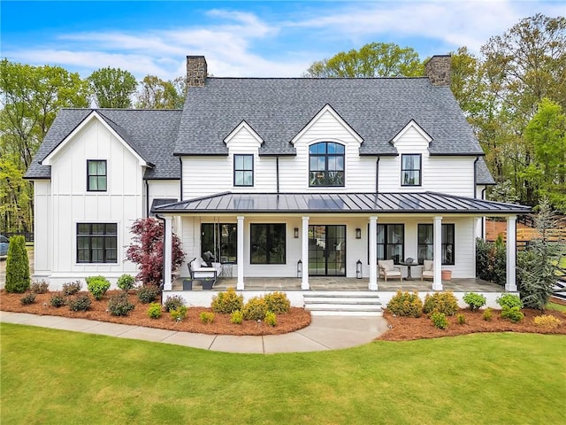 modern inspired farmhouse featuring a front yard and covered porch