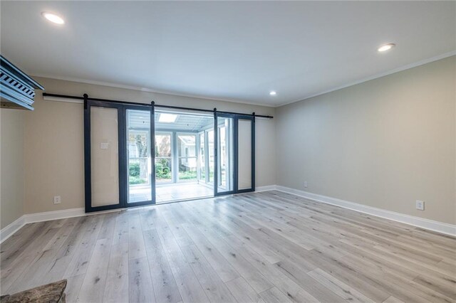 6700 Roswell Rd Unit 21E, Sandy Springs, GA 30328 - spare room featuring ornamental molding, wood finished floors, a barn door, and recessed lighting