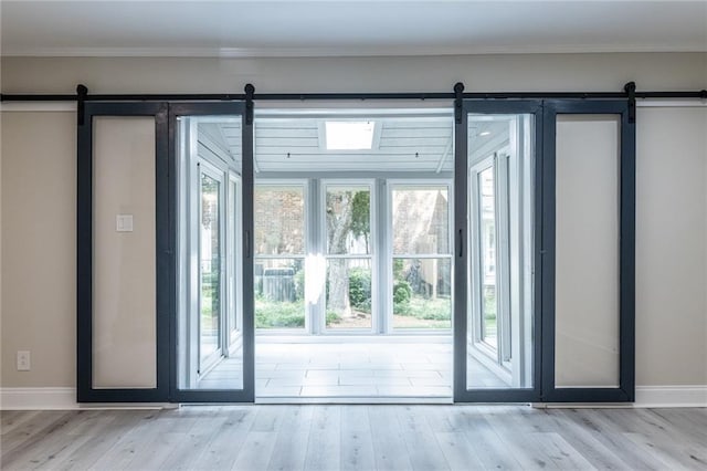6700 Roswell Rd Unit 21E, Sandy Springs, GA 30328 - doorway to outside featuring a barn door, plenty of natural light, and wood finished floors