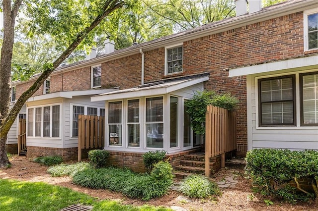 6700 Roswell Rd Unit 21E, Sandy Springs, GA 30328 - back of house featuring a chimney, a sunroom, and brick siding