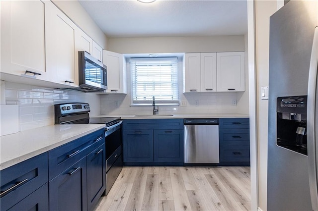 6700 Roswell Rd Unit 21E, Sandy Springs, GA 30328 - kitchen featuring stainless steel appliances, white cabinets, backsplash, and light wood-style floors