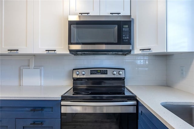 6700 Roswell Rd Unit 21E, Sandy Springs, GA 30328 - kitchen with stainless steel appliances, white cabinetry, and light stone counters