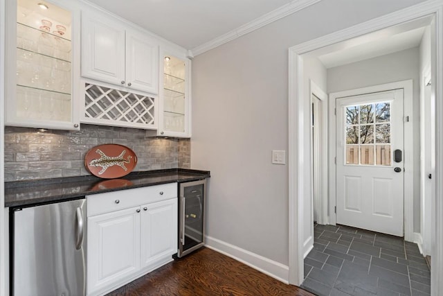 kitchen featuring wine cooler, backsplash, white cabinetry, and refrigerator