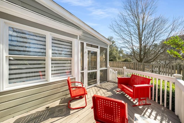 wooden deck featuring a sunroom and fence