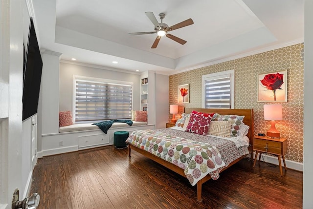 bedroom featuring baseboards, a tray ceiling, hardwood / wood-style floors, and wallpapered walls