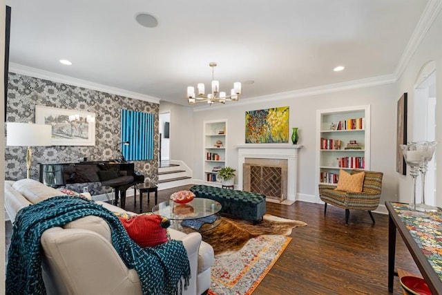 living room with ornamental molding, dark hardwood / wood-style floors, a notable chandelier, and built in shelves