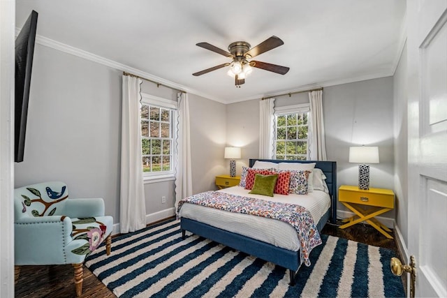 bedroom with a ceiling fan, crown molding, baseboards, and wood finished floors