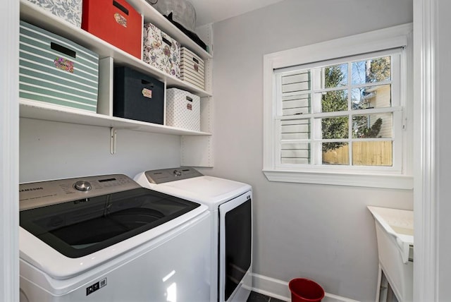 washroom featuring laundry area, separate washer and dryer, and baseboards