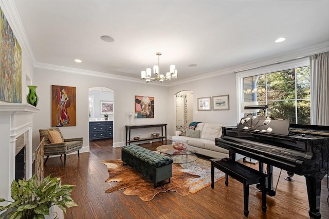 living area with arched walkways, a fireplace, crown molding, and wood finished floors