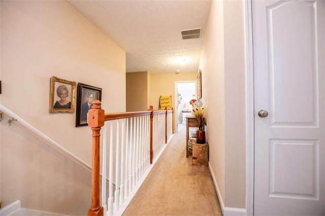 613 Hemlock Ct, Villa Rica, GA 30180 - hallway featuring baseboards, an upstairs landing, visible vents, and light carpet