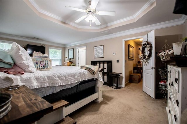 bedroom featuring ornamental molding, a tray ceiling, light carpet, and ceiling fan