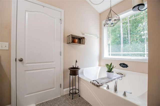 bathroom with baseboards and a bath