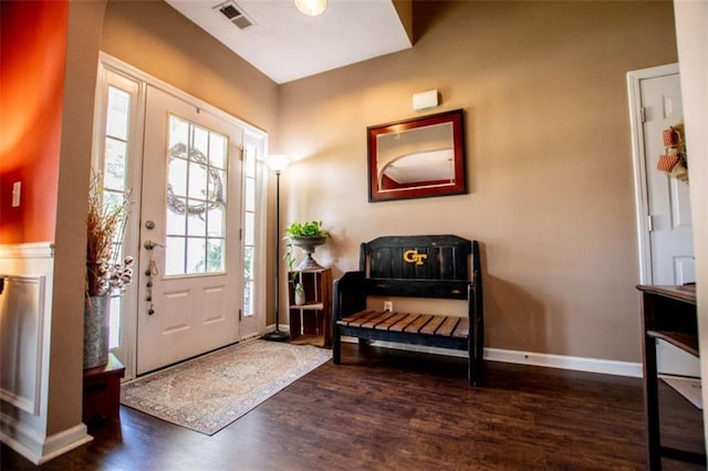 foyer with baseboards, visible vents, and wood finished floors