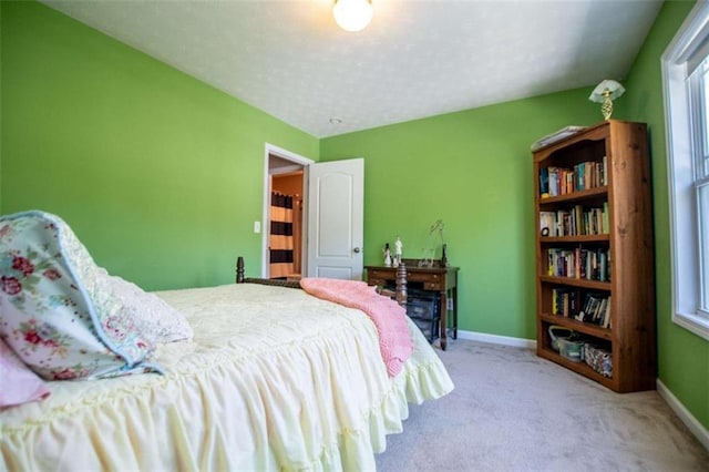 bedroom with carpet flooring, a textured ceiling, and baseboards