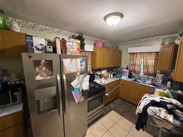 kitchen featuring light tile patterned floors, appliances with stainless steel finishes, and light countertops