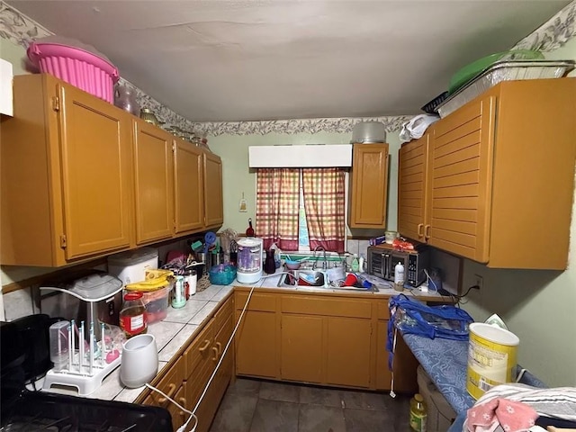 kitchen featuring tile counters and a sink