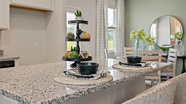 kitchen with light stone countertops and white cabinets