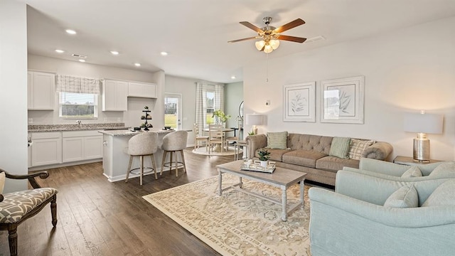 living room with sink, dark hardwood / wood-style floors, and ceiling fan