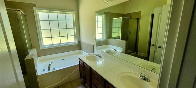 bathroom with tile patterned flooring, plus walk in shower, and vanity