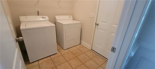 laundry room featuring independent washer and dryer and light tile patterned flooring