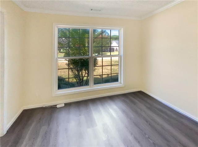 unfurnished room with visible vents, baseboards, dark wood finished floors, and ornamental molding