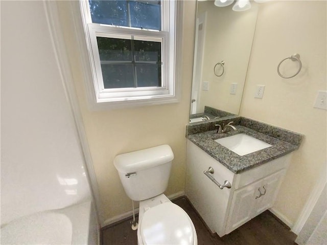 bathroom featuring vanity, toilet, and baseboards