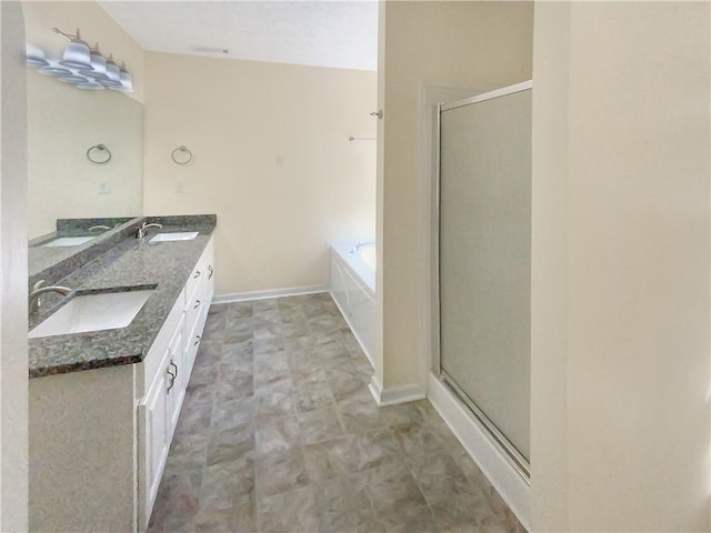 bathroom featuring a garden tub, double vanity, a stall shower, and a sink