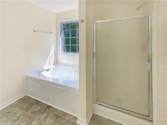 full bathroom with a shower stall and a bath