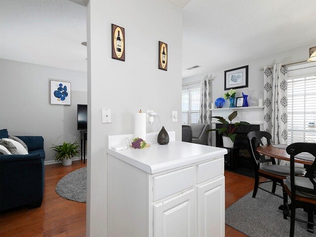 kitchen with hardwood / wood-style floors and white cabinets