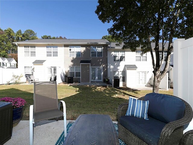 exterior space featuring french doors, a front lawn, and a patio