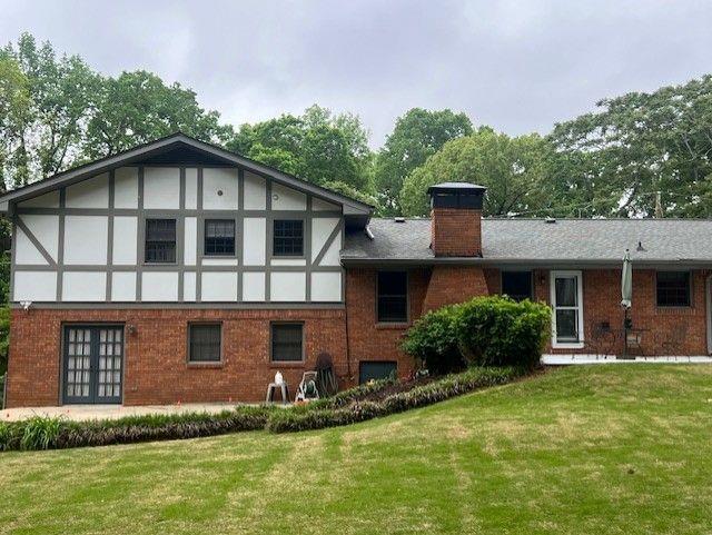 3996 Indian Manor Dr, Stone Mountain, GA 30083 - back of property with a chimney, brick siding, and a lawn