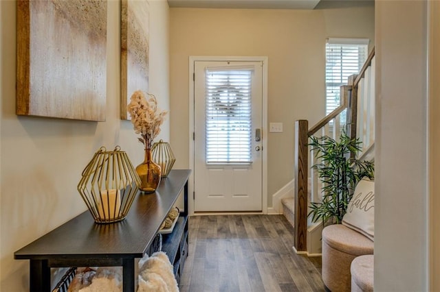 entryway featuring dark wood-style floors, stairway, baseboards, and a healthy amount of sunlight