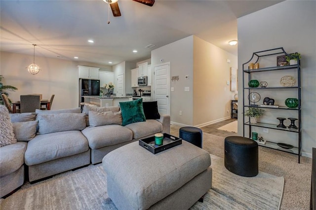 living area with recessed lighting, light carpet, and baseboards