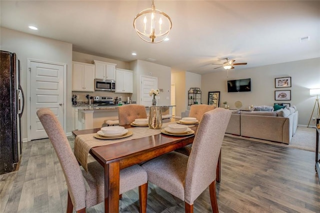 dining room with recessed lighting, visible vents, light wood-style flooring, baseboards, and ceiling fan with notable chandelier