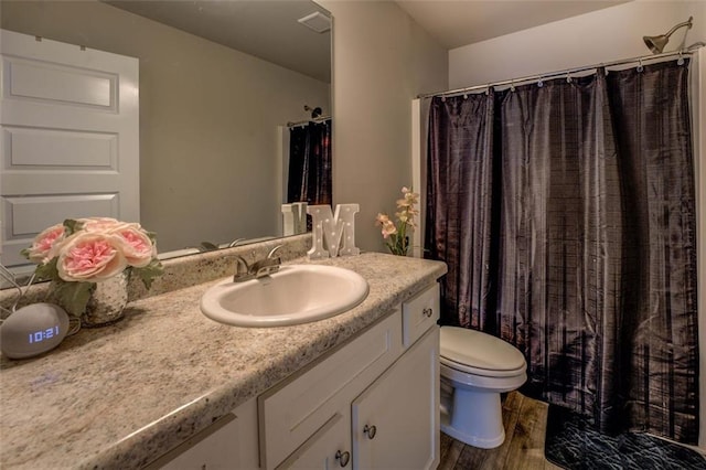 bathroom with toilet, wood finished floors, visible vents, vanity, and a shower with curtain