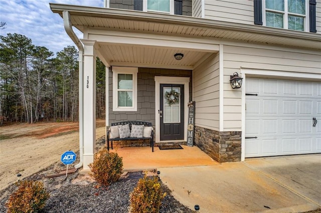 property entrance featuring a garage, stone siding, and a porch