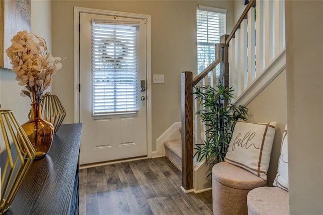 doorway featuring wood finished floors, baseboards, and stairs