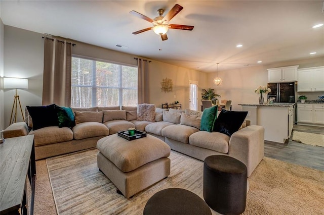 living room with a ceiling fan, visible vents, wood finished floors, and recessed lighting