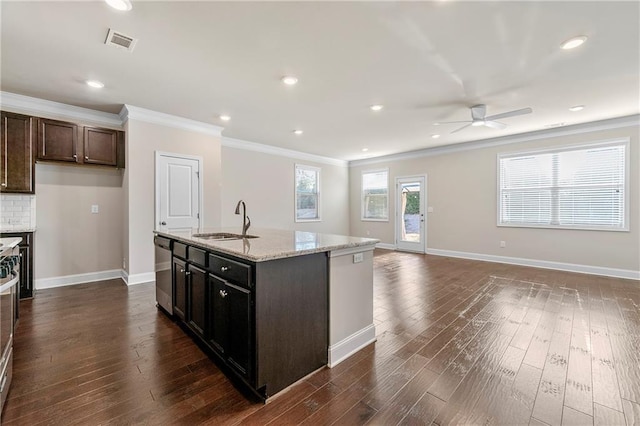 kitchen featuring dishwasher, sink, a kitchen island with sink, light stone counters, and dark wood-type flooring