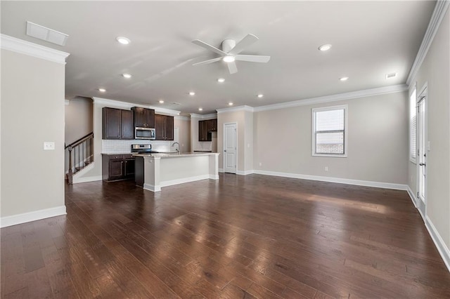 unfurnished living room with ornamental molding, dark wood-type flooring, sink, and ceiling fan