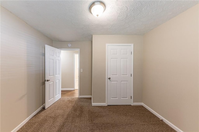 unfurnished bedroom featuring carpet flooring and a textured ceiling