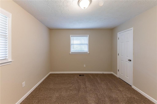 carpeted spare room with a textured ceiling